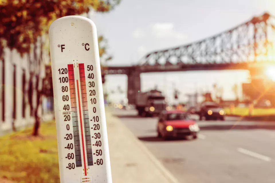 Thermometer infront of blurred image of street during heat wave
